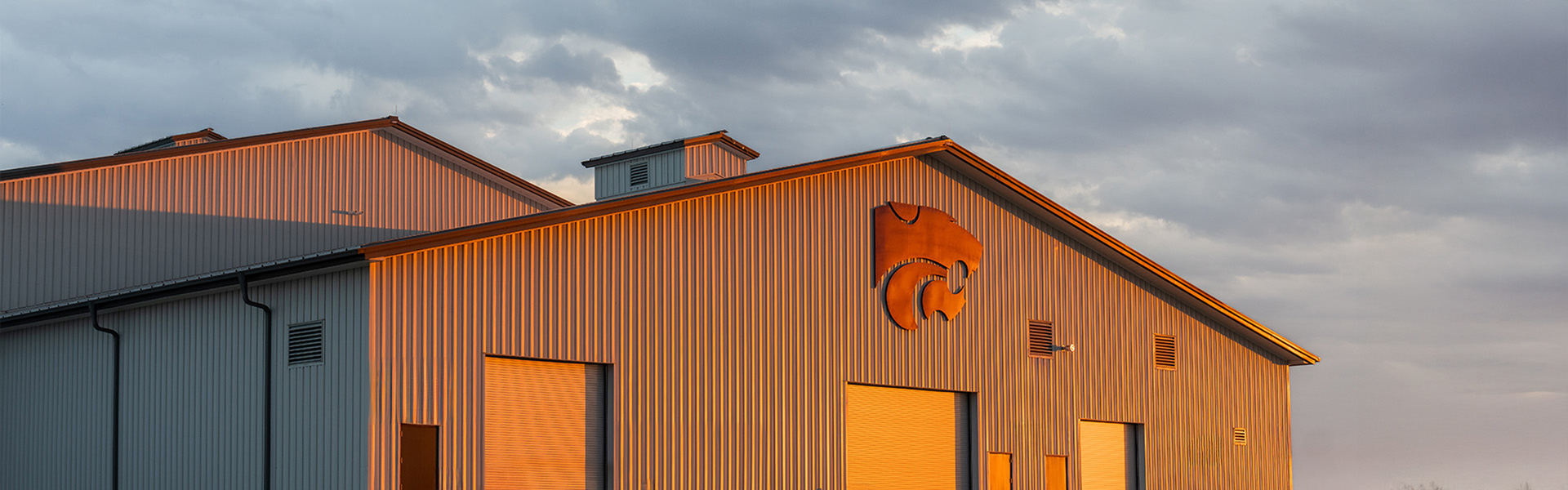 Metal building exterior with a Powercat logo at sunset