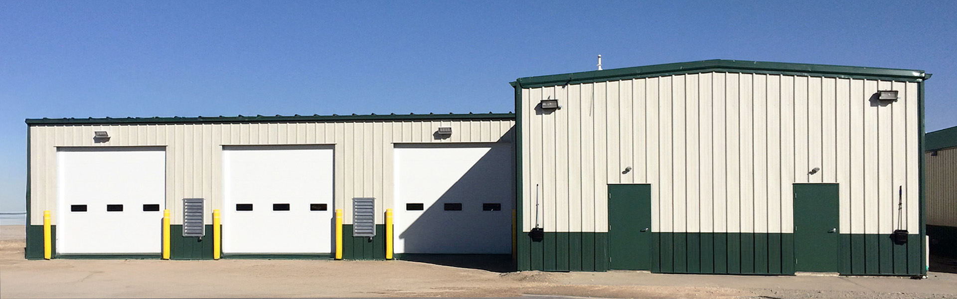 bus maintenance service building with tan vertical rib wall panels and green trim