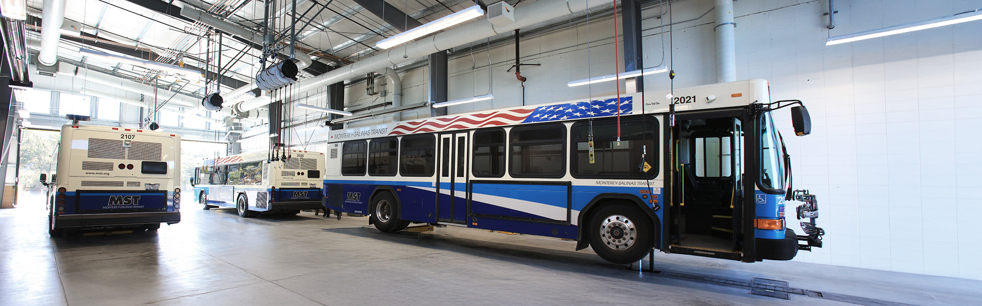 Operations transit bus maintenance bay with exposed steel framing and lights