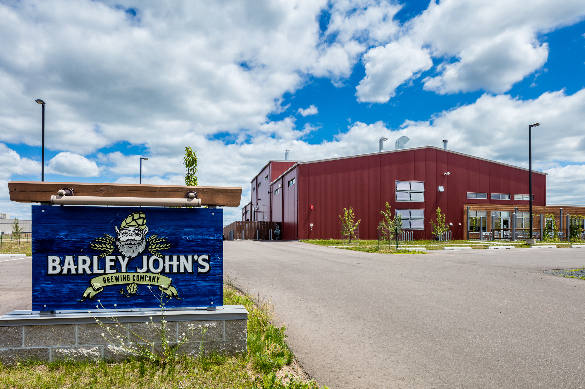 Barley John’s branded sign in front of a red metal brewery building