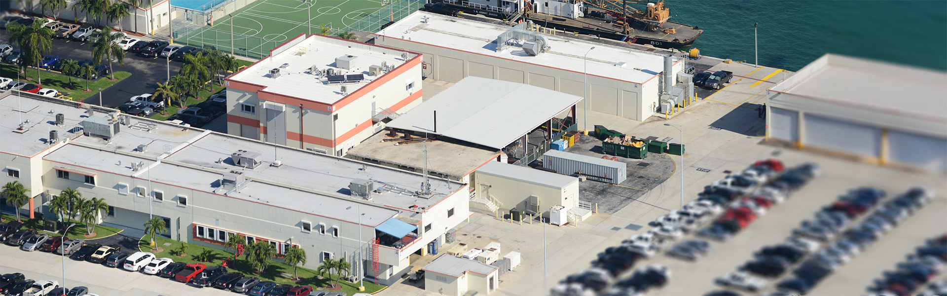 U.S. Coast Guard Fast Response Cutter Support waterfront facility with white metal roofs