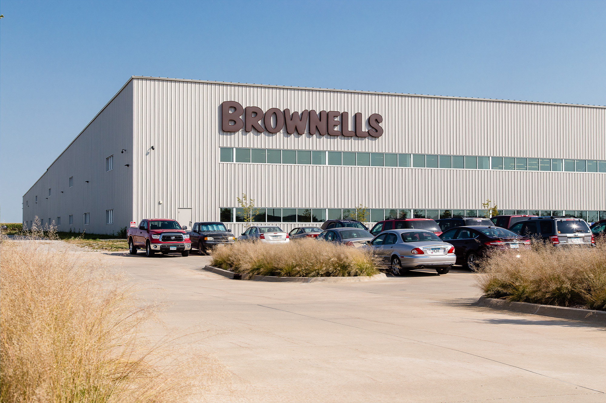 Brownells distribution building with light gray vertical rib siding and clerestory window band