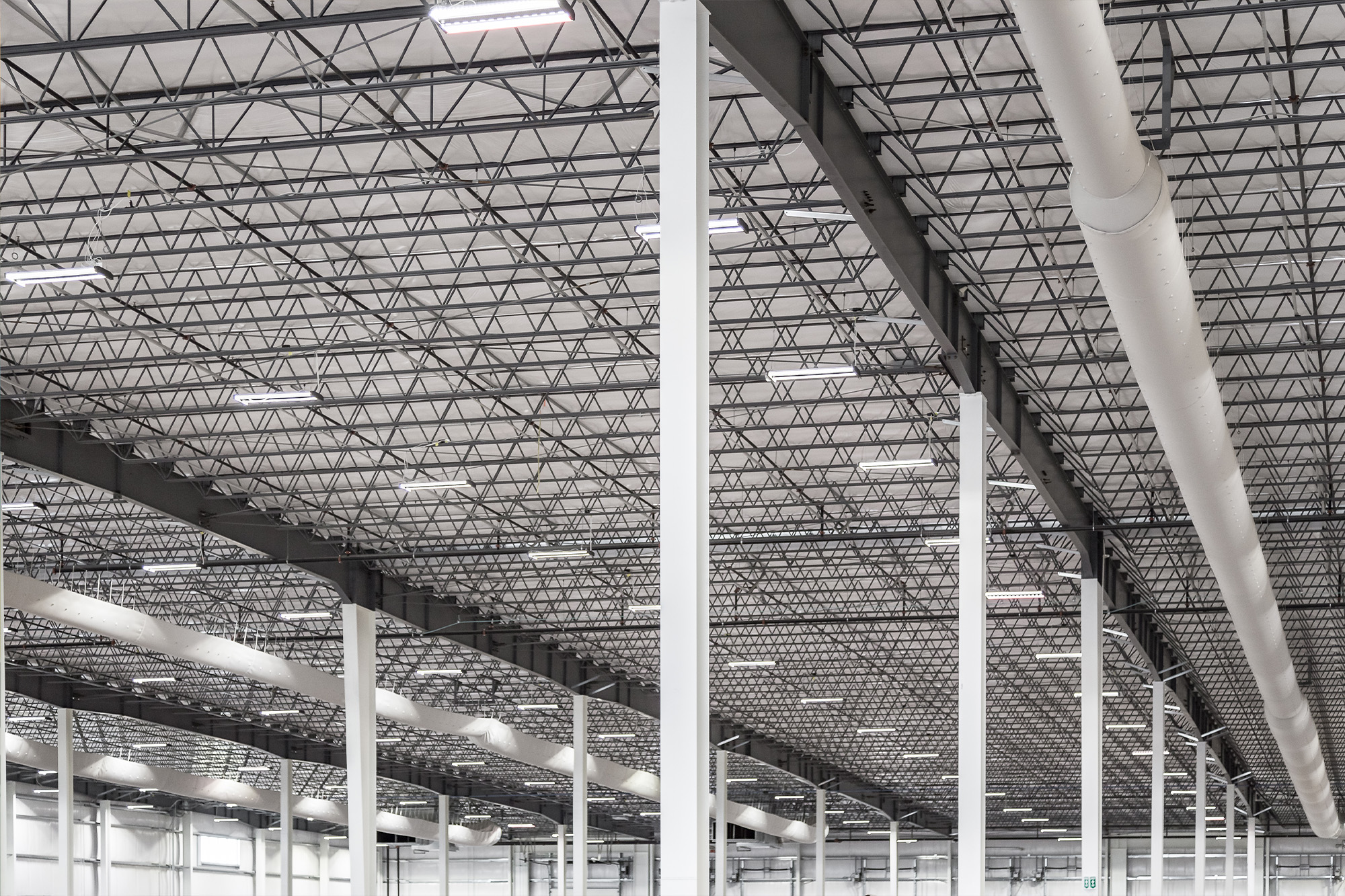 Brownells warehouse with steel joists, white steel columns and long runs of exposed ductwork