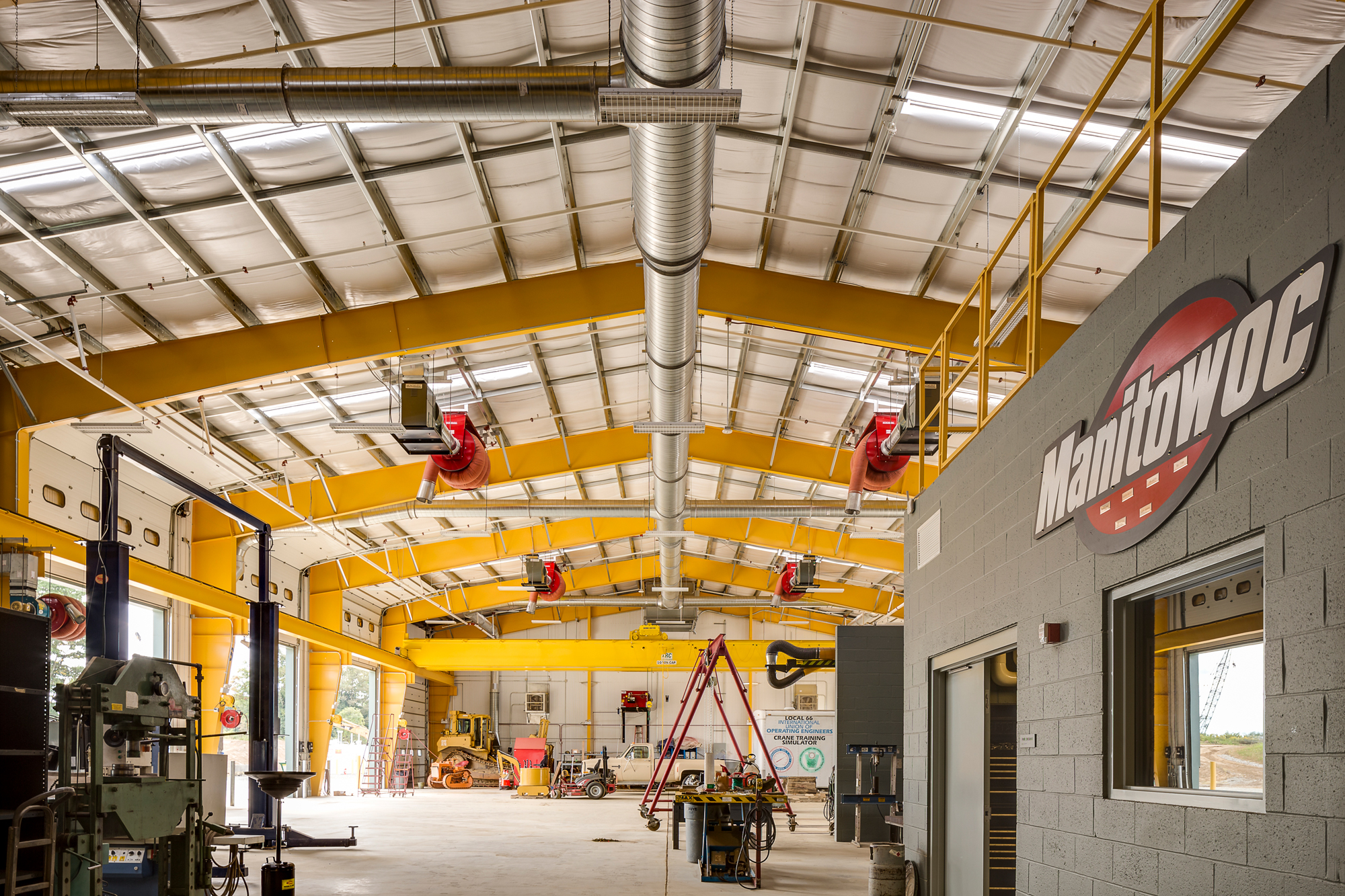 Industrial workshop interior with yellow steel framing and overhead ductwork