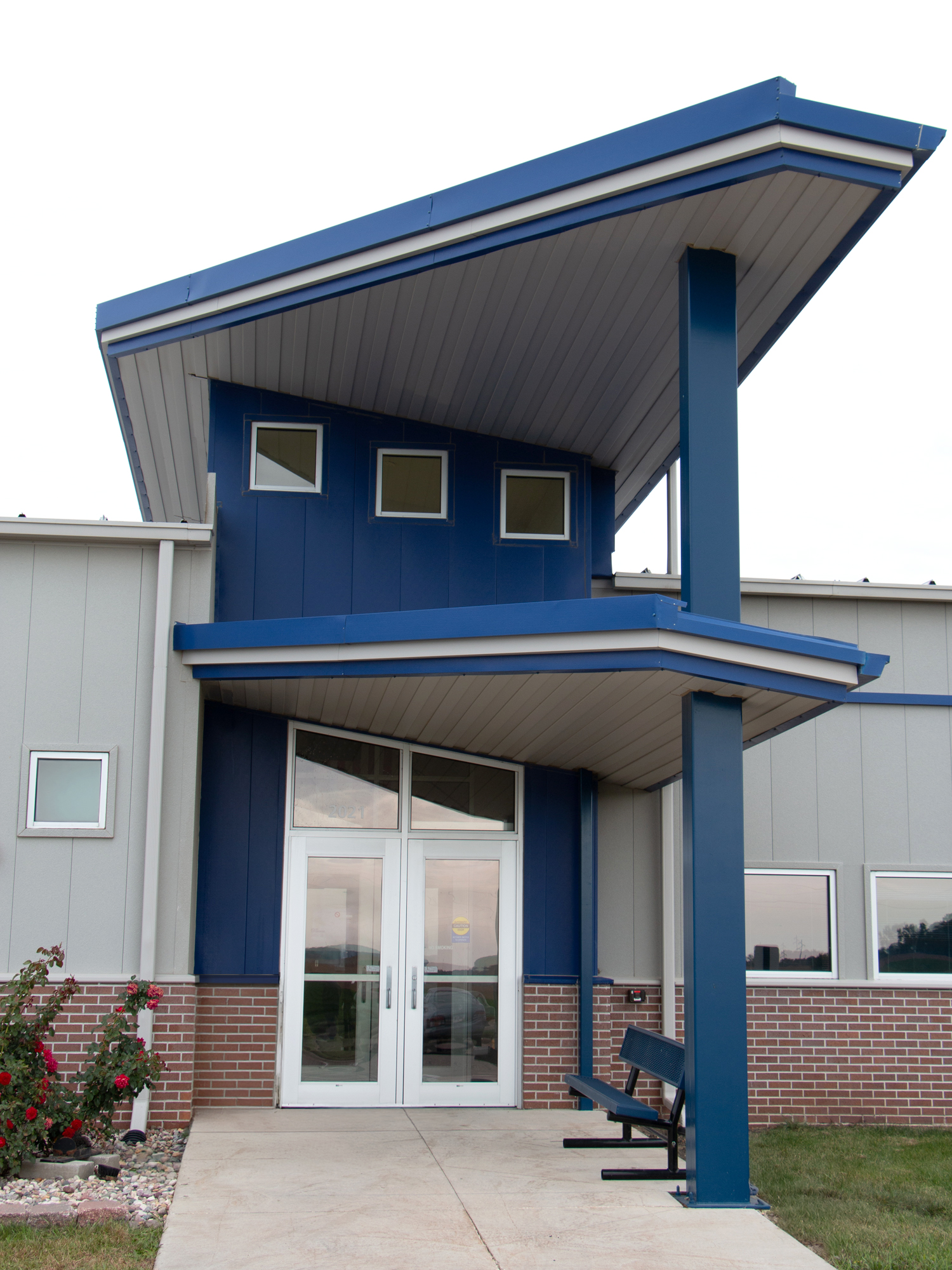 Iowa Lakes Community College building entrance with blue cantilevered canopy