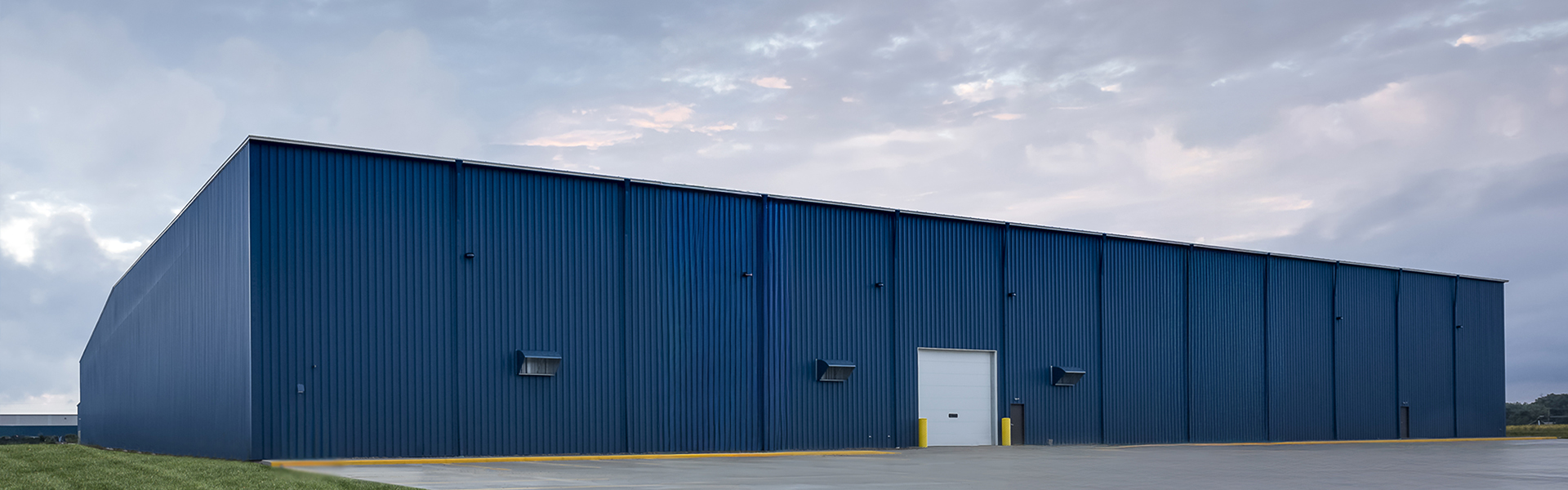 Burr Oak Tool metal warehouse with vertical rib wall panels and a white service door