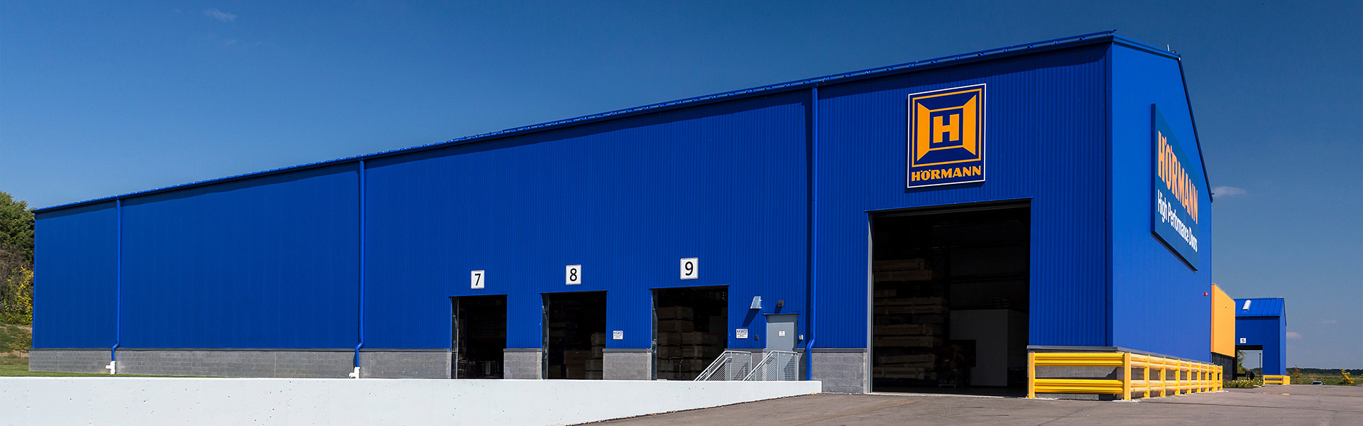 Hörmann warehouse with vertical rib wall panels, loading bays and large overhead door