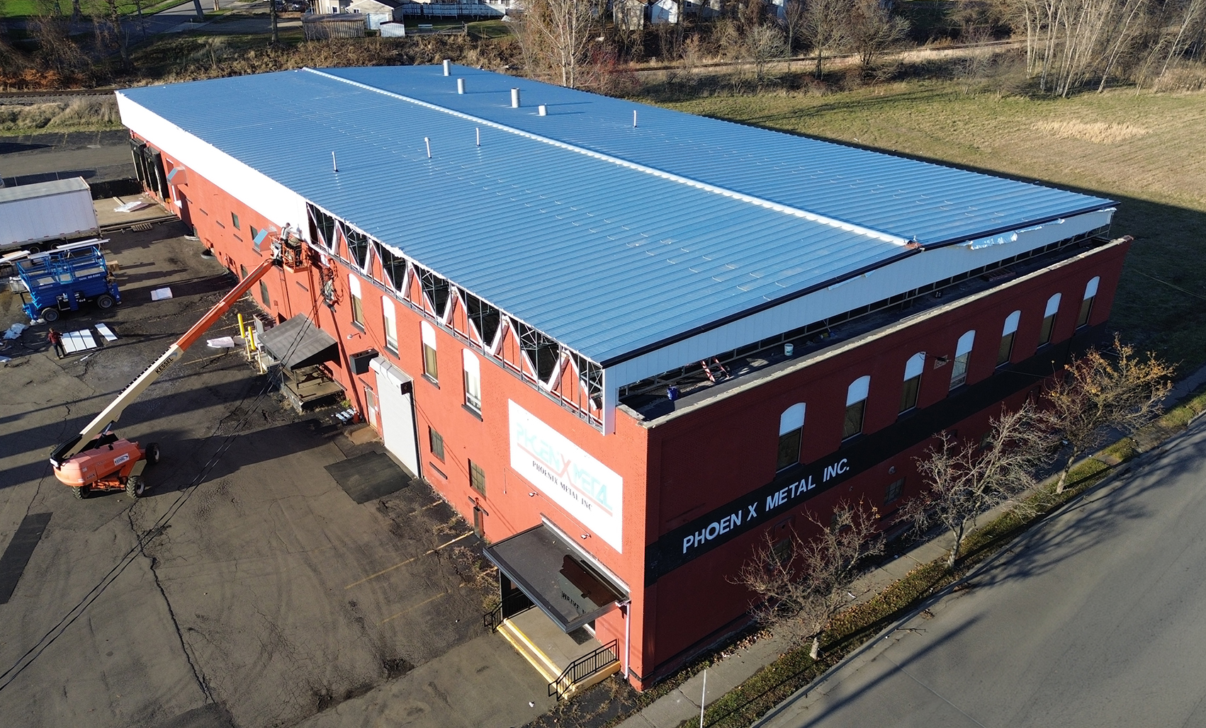Aerial view of the Phoenix Metal building during a Butler roof retrofit, featuring newly installed blue metal roof panels and engineered steel framing designed to extend building life and performance.