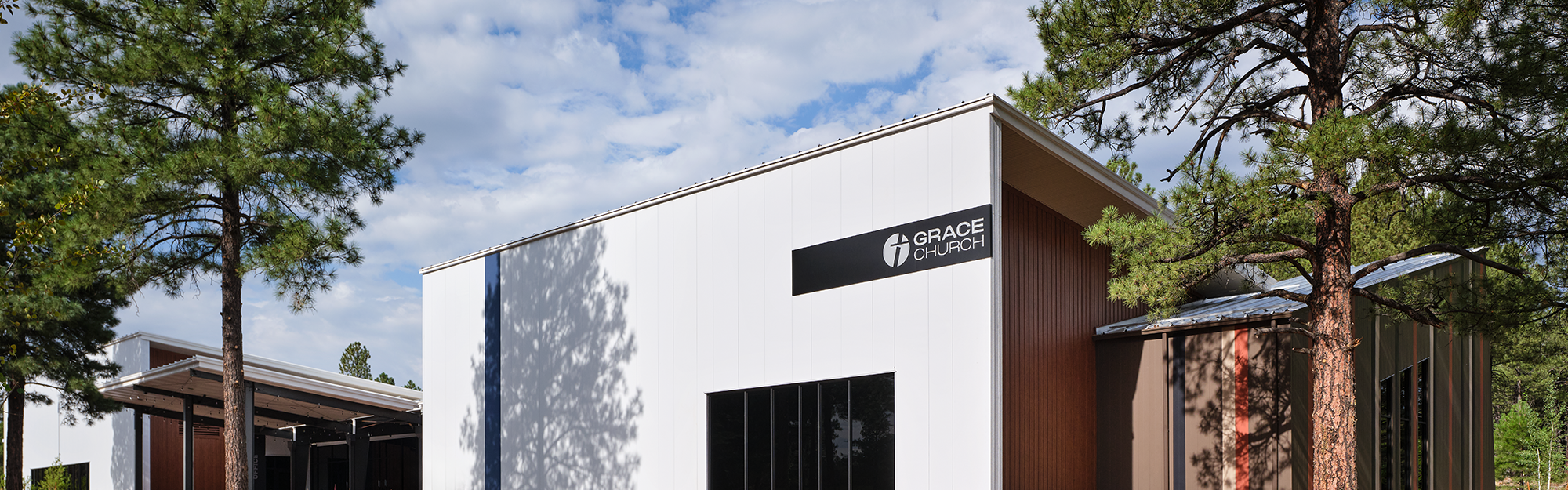 Grace Community Church exterior with white metal panel facade and wood accents