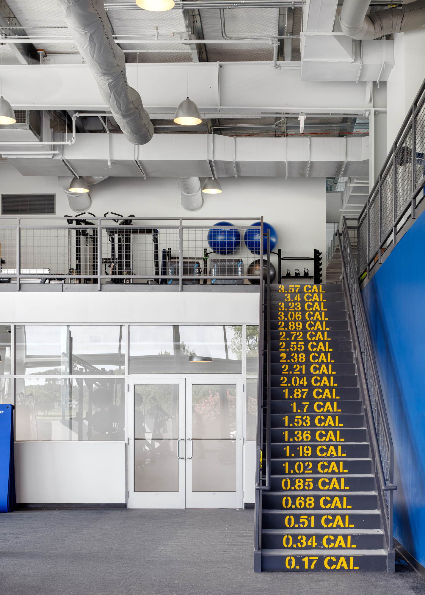 Dupont Country Club gym interior with fun stairway, exposed ductwork and mezzanine training area