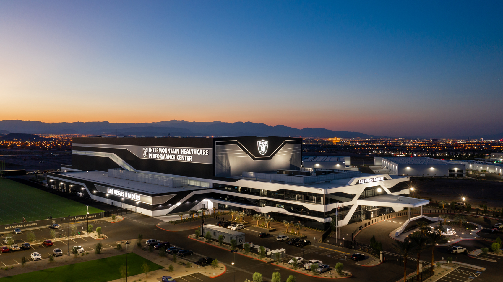 Las Vegas Raiders indoor practice facility at dusk featuring a Butler-built metal structure.