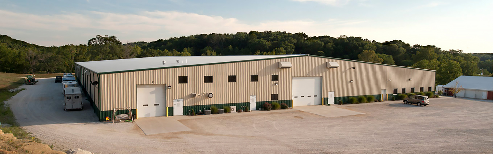 metal arena building with vertical rib wall panels, multiple overhead doors, and loading apron