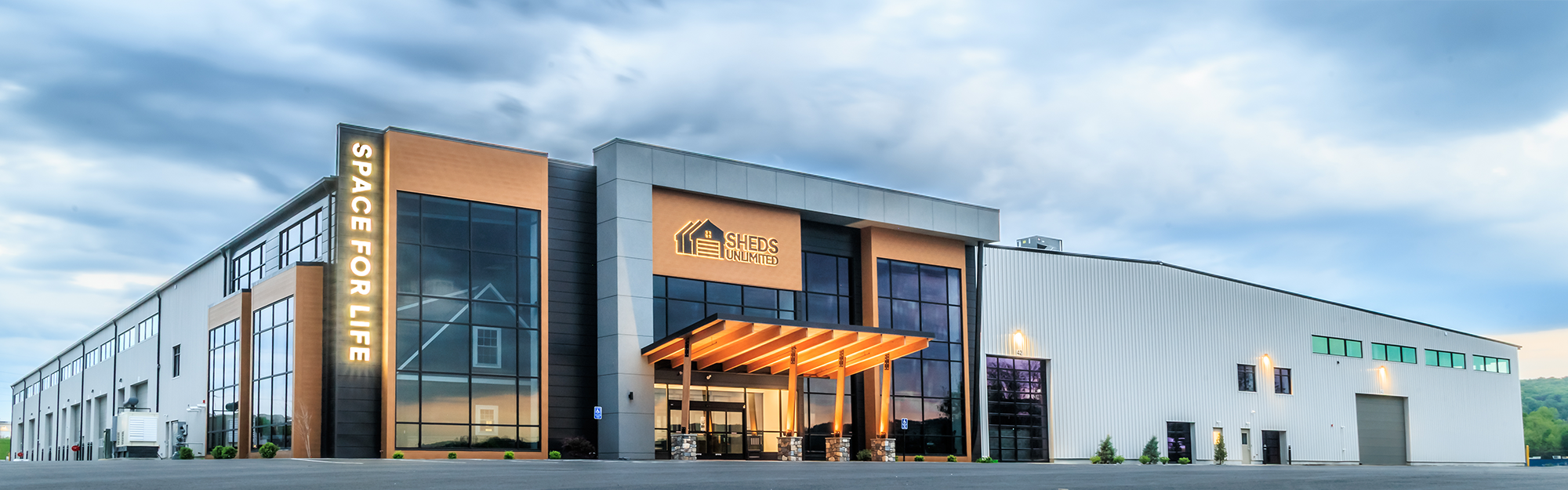 Storage facility exterior with glass entry tower, metal panel facade and timber canopy