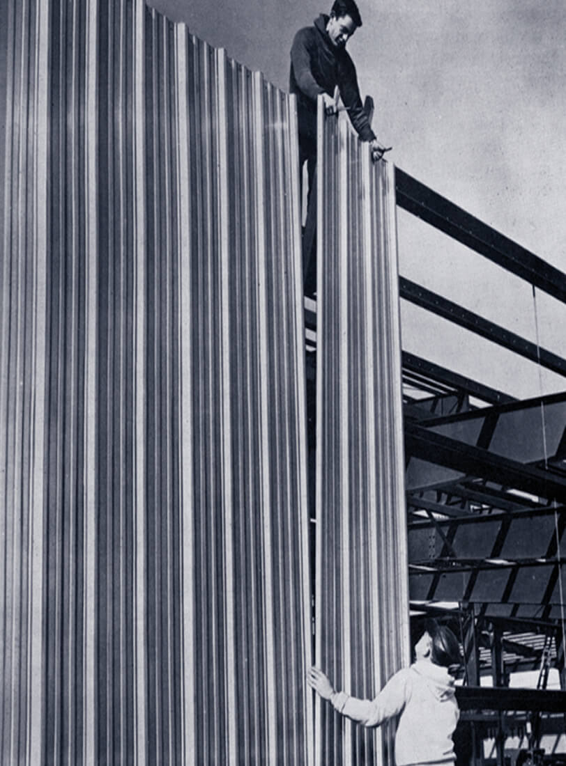 vintage image of workers installing corrugated metal wall panels