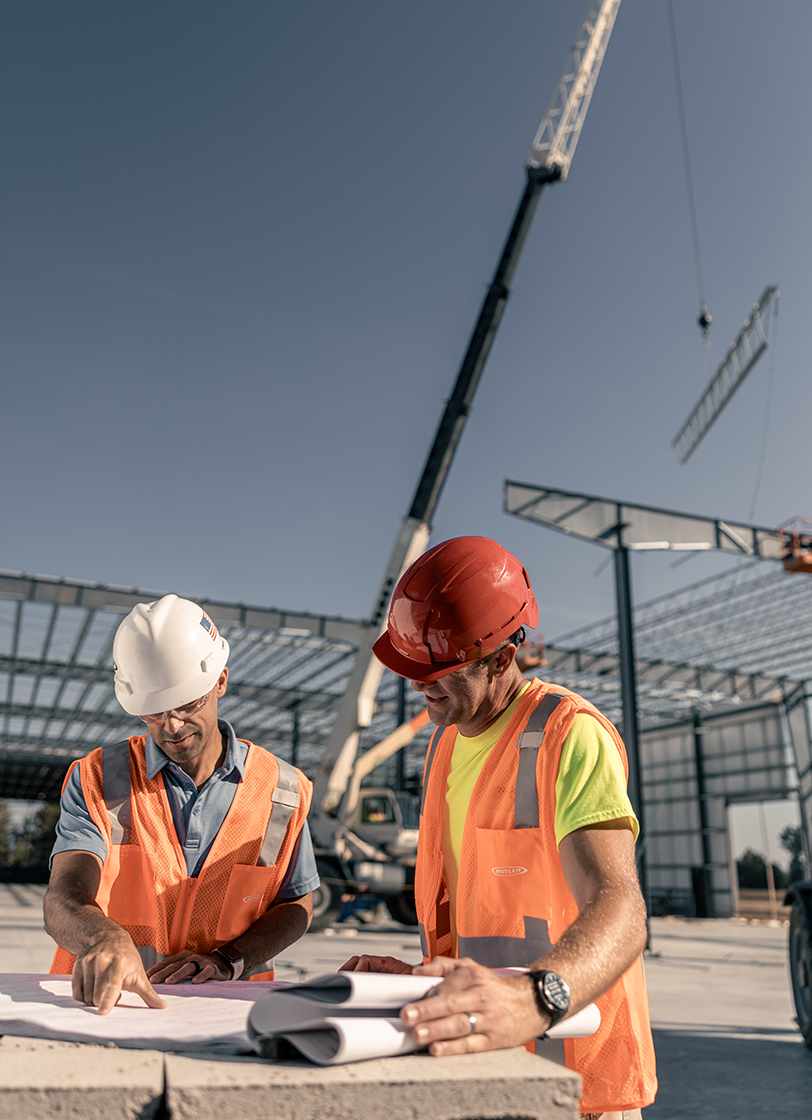 Builders reviewing metal building plans on jobsite