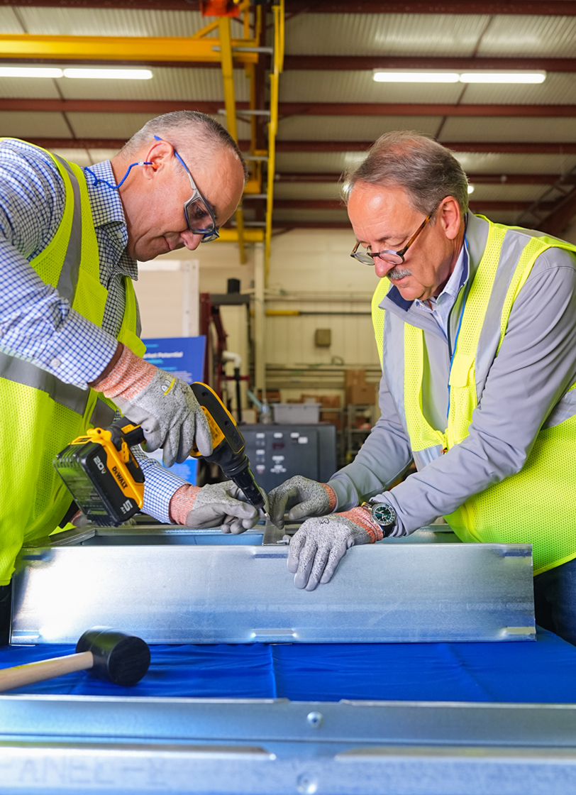 Workers assembling steel components in factory