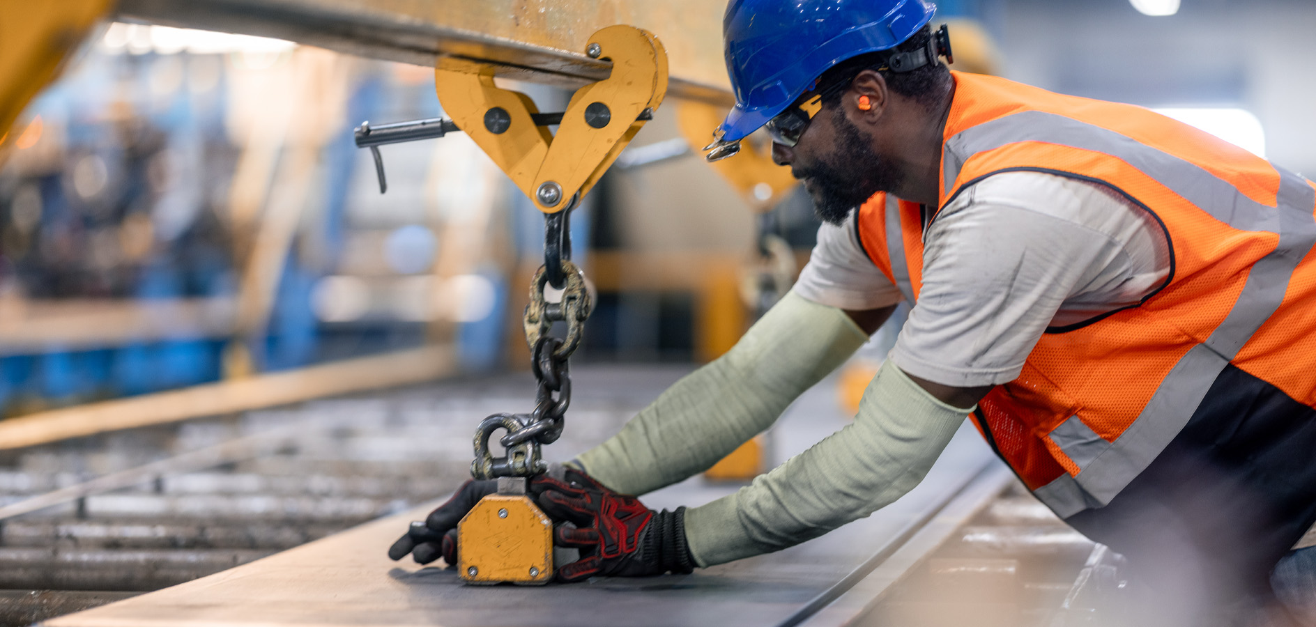 Steel fabrication process with worker positioning material using overhead lifting system.