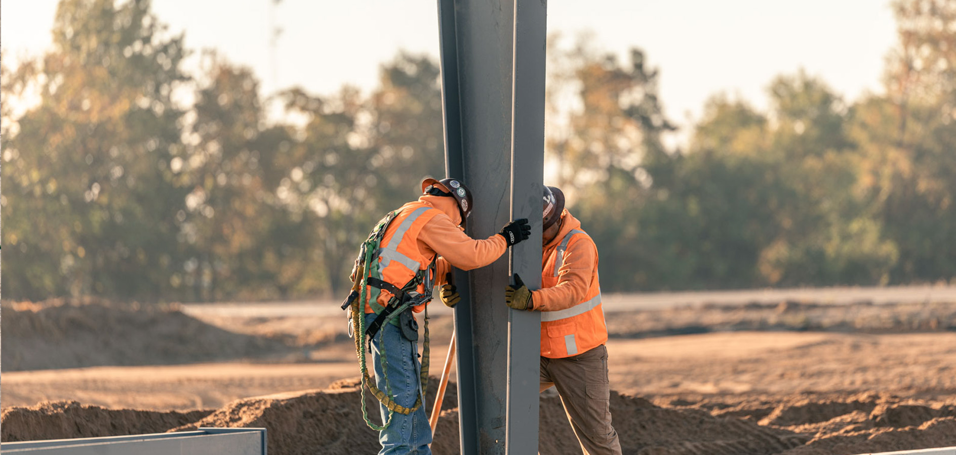 Construction crew aligning a steel column on site during structural installation.