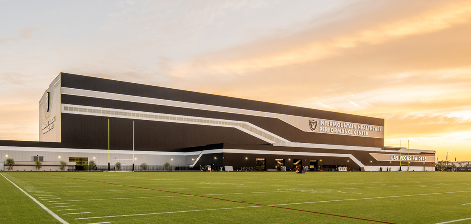 Las Vegas Raiders performance center with black metal panel facade and white ribbon stripe