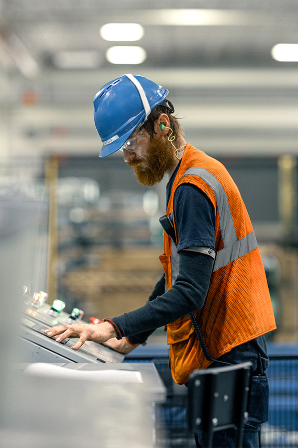 Industrial worker operating control panel in an steel manufacturing facility