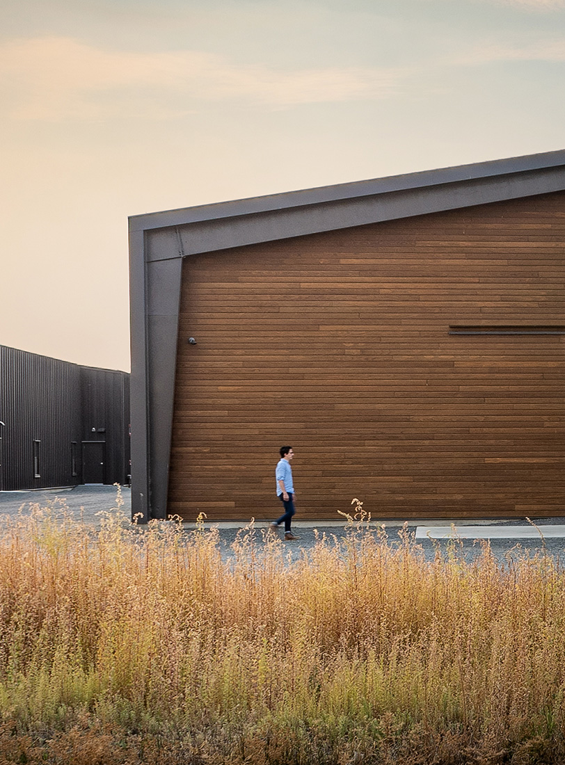 Man walking past modern wooden building